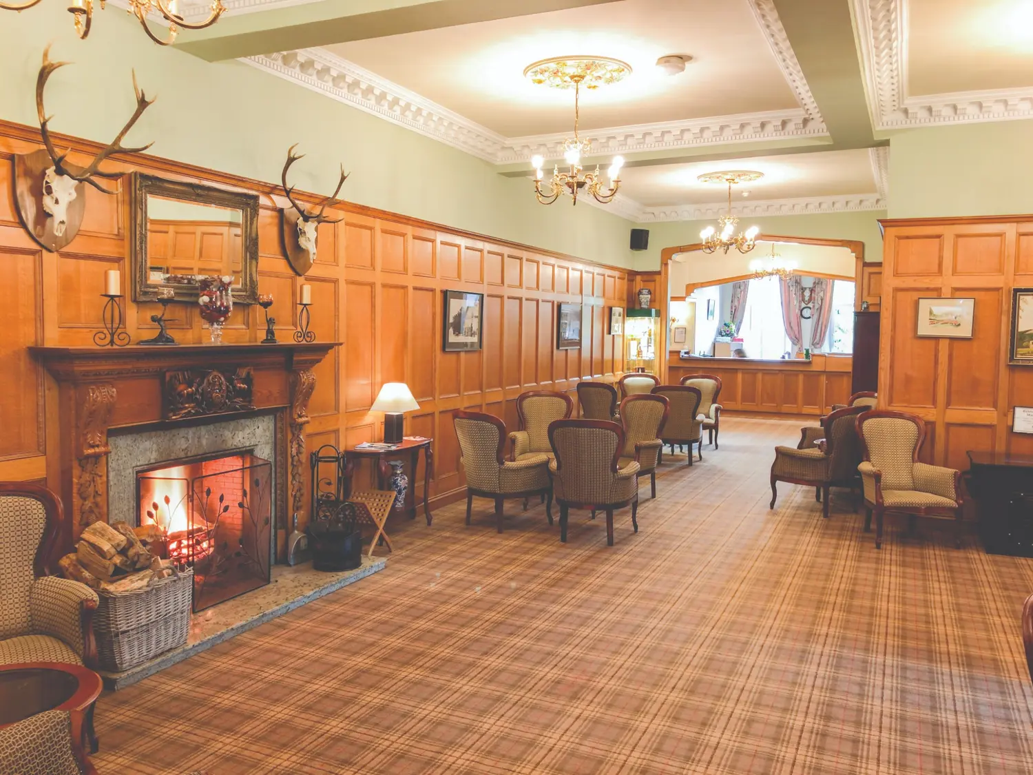 The oak-panelled Great Hall and open fire at the Duke of Gordon Hotel